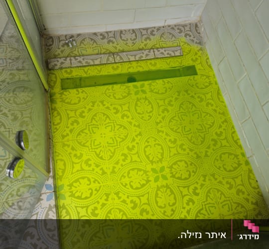 רצפת מקלחת עם אריחים מעוצבים ודלת זכוכית